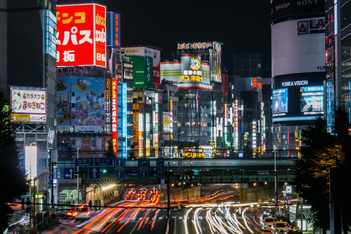 一个繁忙的日本都市风景与飘洒的灯迹小径由高建筑物嗖嗖嗖嗖