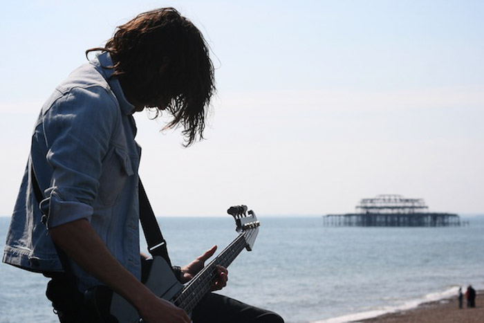 一个在海边弹吉他的男人，在摄影中没有注意平衡