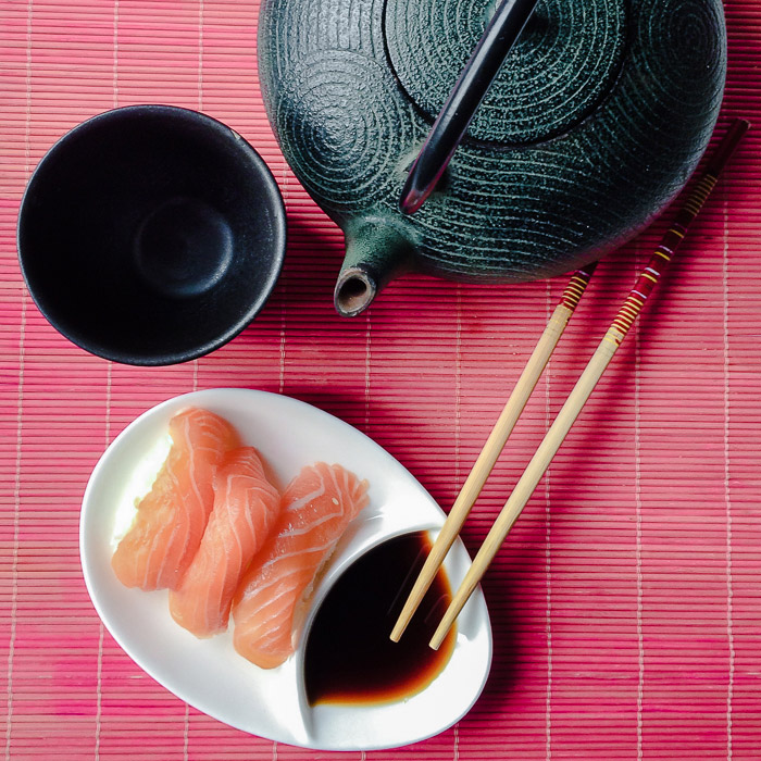 一张寿司、茶壶和茶杯的头顶照片，用于静物摄影