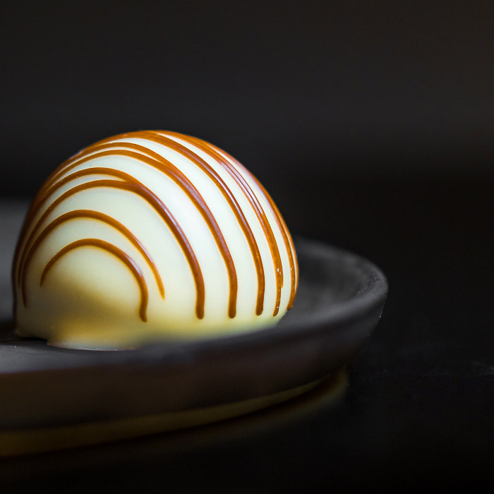 用焦糖装饰的比利时白巧克力的近距离食物摄影。