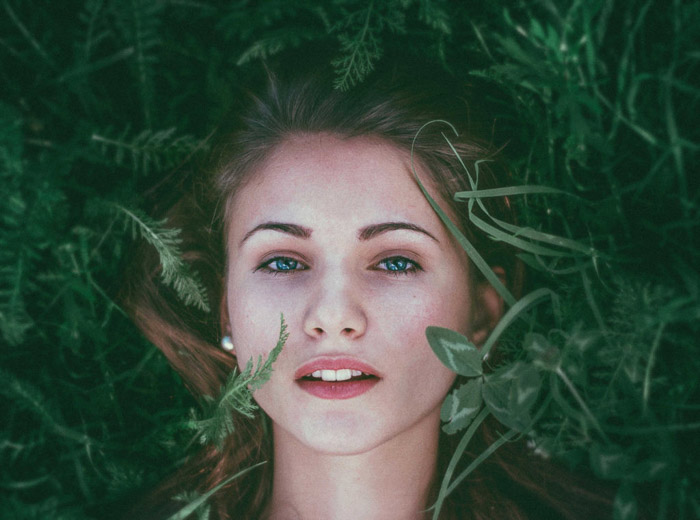 躺在草的一名红发妇女的画象照片