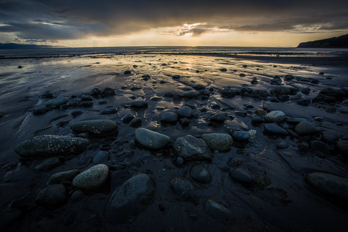 沿海摄影：在黄昏的浅水区的深色岩石