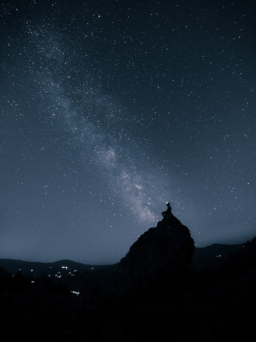 惊人的天线图射击了一个星上填装的天空在岩石的一个人的剪影