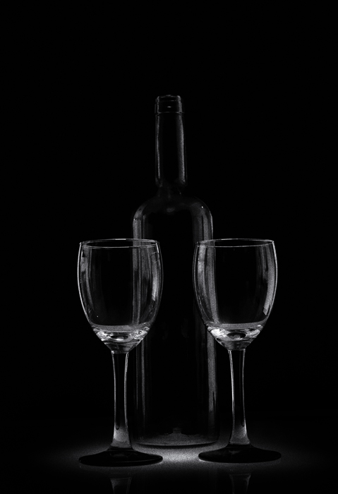 两杯和玻璃瓶坐在低调的黑暗环境中