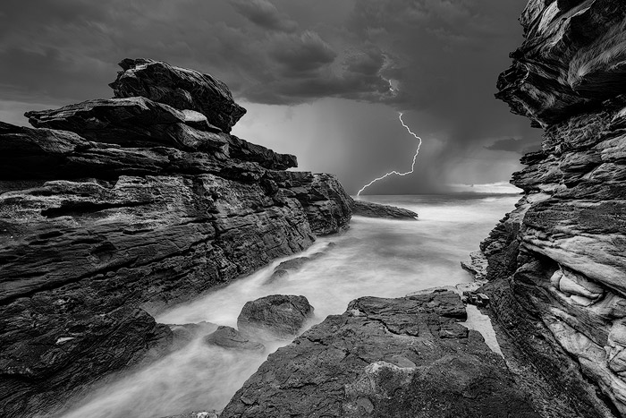 闪电在岩石海景上醒目