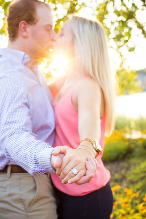 一对接吻的夫妇的订婚照片，注意到戒指的照片是用反光镜拍摄的