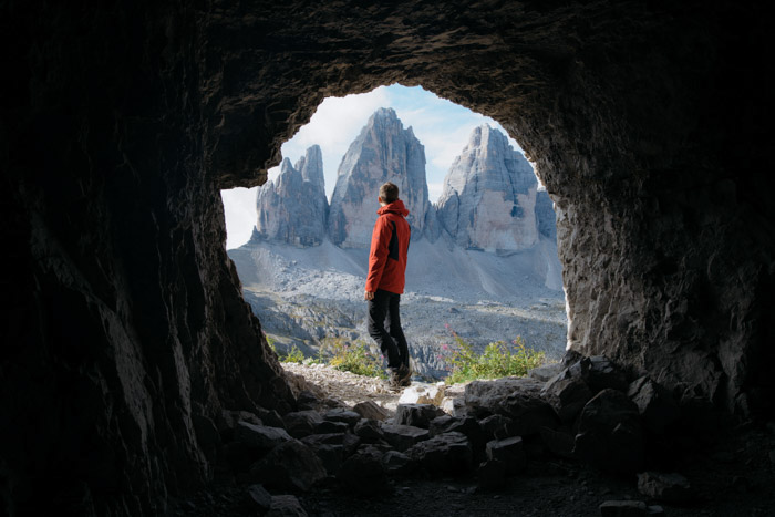 在前景中的一个洞穴的徒步旅行者自然框架