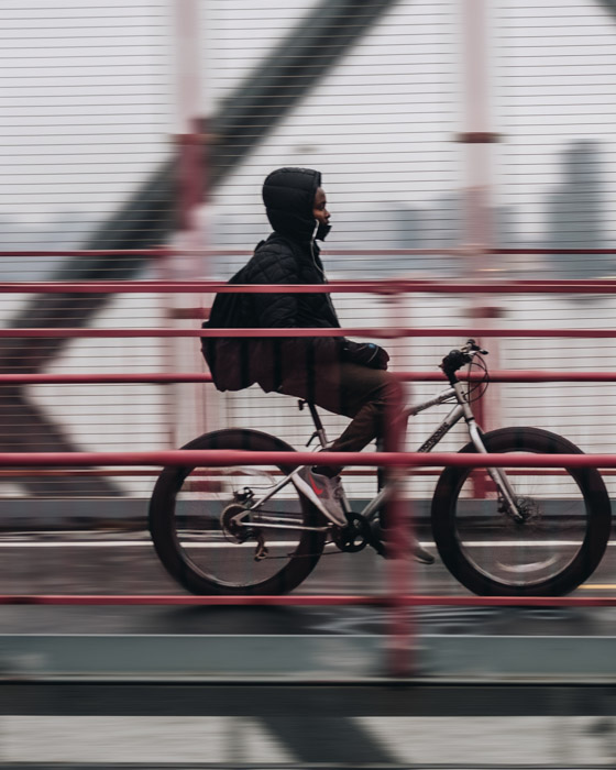 一个播种的射击横跨桥梁骑自行车的人