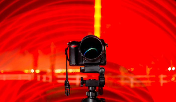 在三脚架上的一个dslr相机包围着红灯螺旋形。