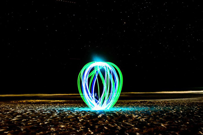 晚上在海滩上画一个绿色和蓝色的圆球。