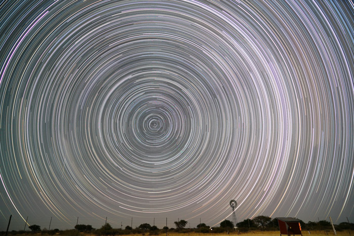 这是一幅令人惊叹的天体摄影照片，拍摄的是夜空中星星轨迹的圆形图案