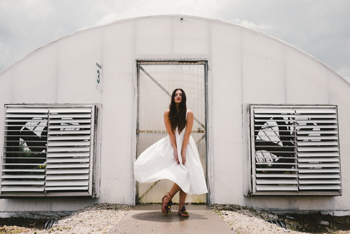 编辑时装拍摄的一个模特在户外摆姿势的白色连衣裙
