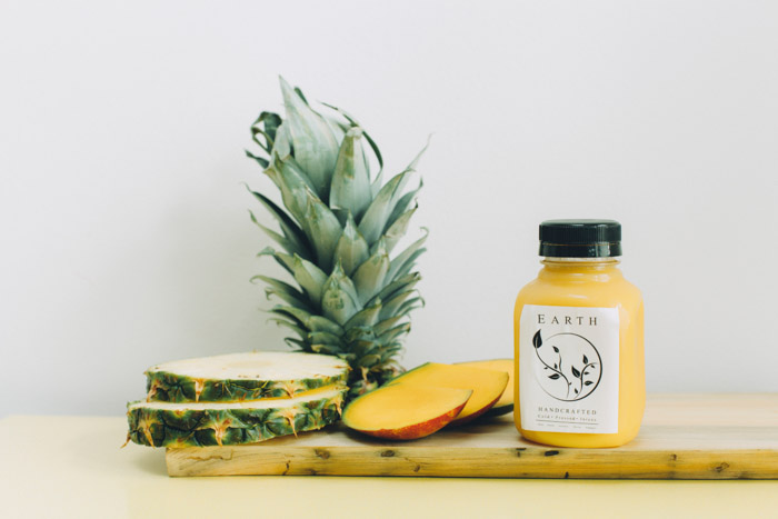 一个产品摄影拍摄的菠萝和产品瓶在一个木制砧板上