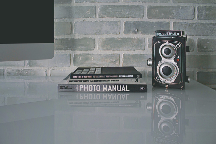 一台roliflex相机和摄影书籍搁在桌子上——手动相机设置