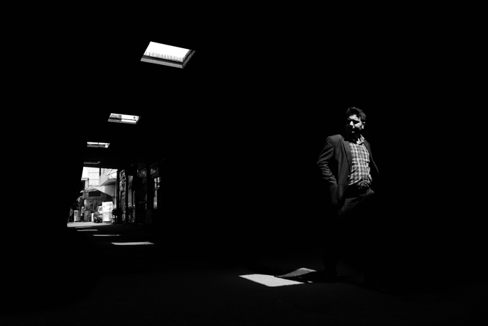 一名男子走过过道的街景，用黑白胶片拍摄