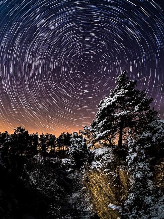 在一个峭壁的一个孤立的杉树在一个经典星径下以北极星为中心。