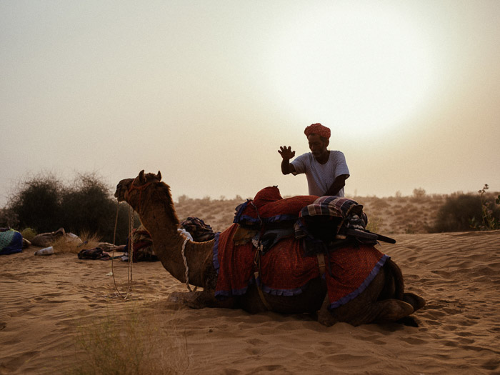 站立在沙漠的一个人的一个人的画象在沙漠，在他后的一个美丽的透镜火光