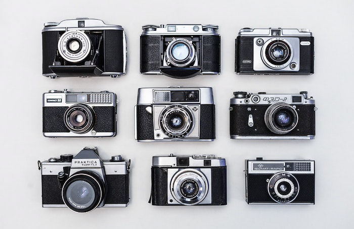 一个平铺的九部旧胶卷相机在白色的背景-专业的照片拍摄