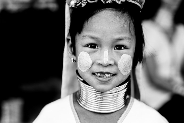 一个年轻的卡尤女孩的近距离肖像穿着传统的服装和脸上的油漆-浅与深的景深