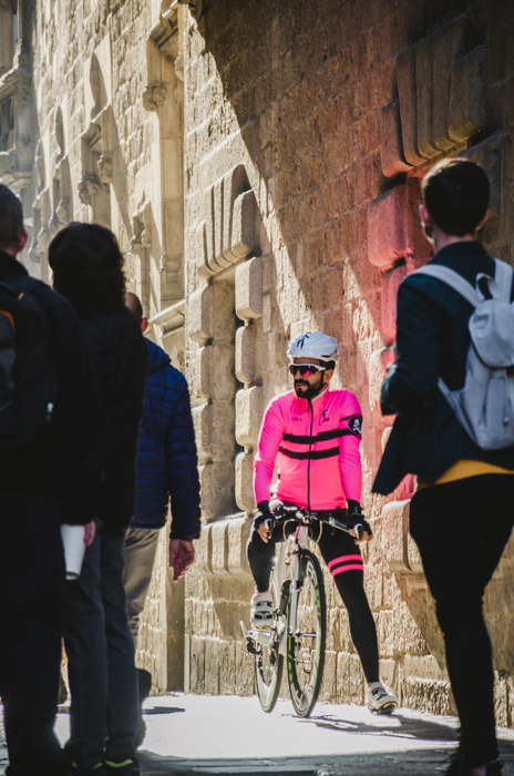街景人们的焦点是一个穿粉红色夹克的摩托车手