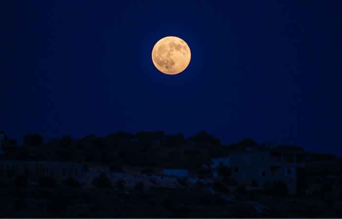 夜晚城镇上空满月的照片
