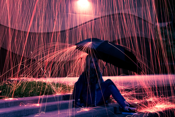 拿着伞的一个女孩在钢羊毛摄影创造的雨作用下