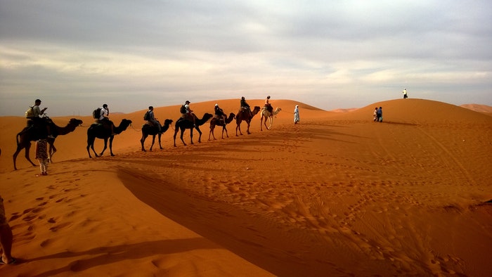 一队骑骆驼的人正在穿越沙漠