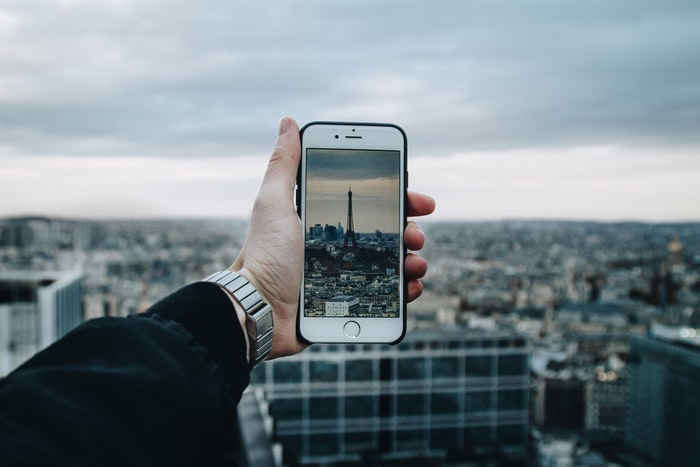 拍艾菲尔铁塔照片的人与智能手机