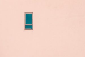 一个小窗口的极简主义摄影在桃红色大厦门面的
