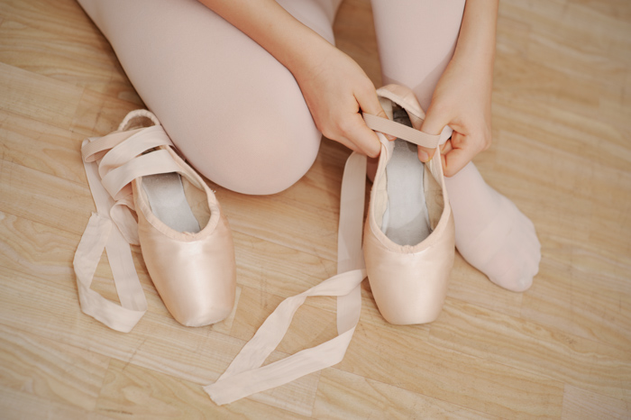 一个女孩的特写穿着她的芭蕾舞鞋-照片道具