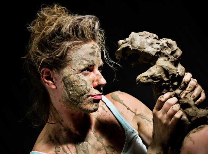 一幅女性陶瓷艺术家用粘土作为摄影道具的肖像